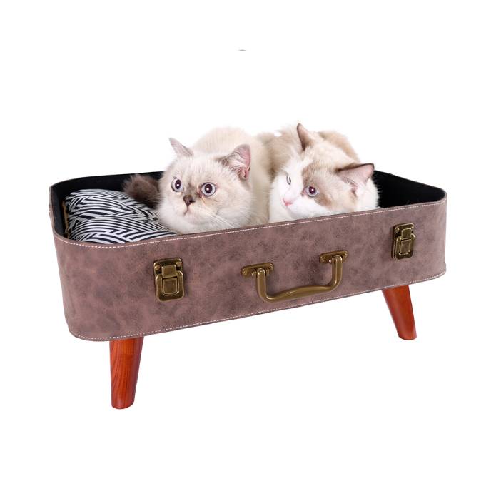 two cats on suitcase bed 